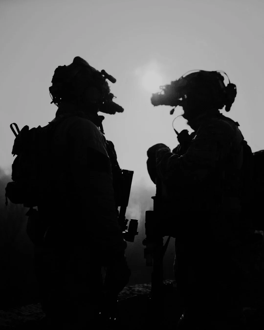Silhouettes of two soldiers wearing night-vision goggles